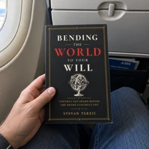 A hand holding Bending the World to Your Will on a plane